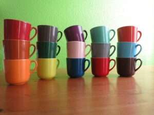 Eine Sammlung an Tassen in verschiedenen Farben. Stellvertretend für die unterschiedliche Versionen.